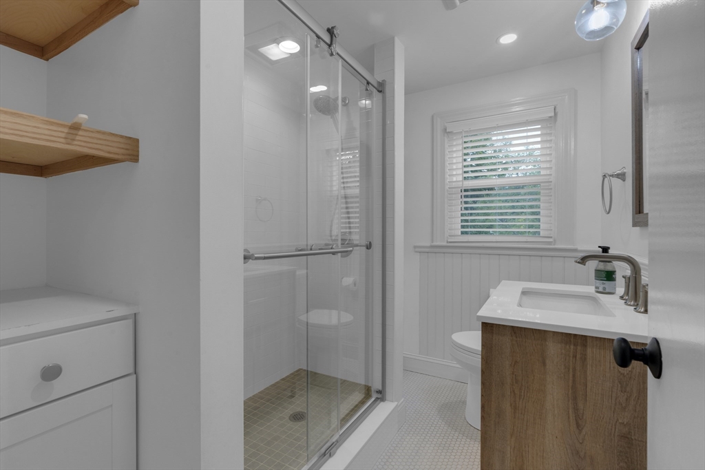 104 Mishawum Road Woburn, MA 01801 - Photo 11 of 13 a bathroom with a granite countertop sink a mirror and a shower