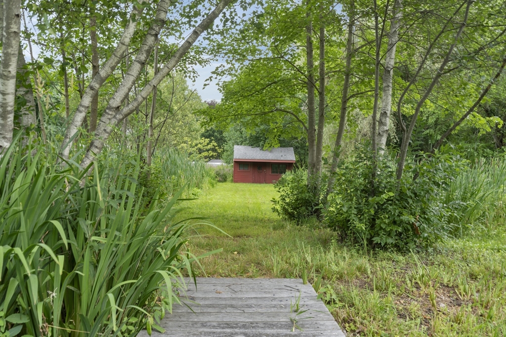 104 Mishawum Road Woburn, MA 01801 - Photo 2 of 13 a view of a garden with a bench