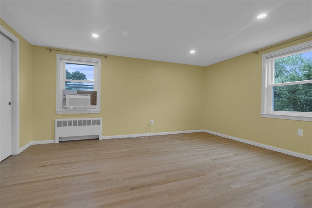 104 Mishawum Road Woburn, MA 01801 - Photo 6 of 13 a view of an empty room with wooden floor and a window
