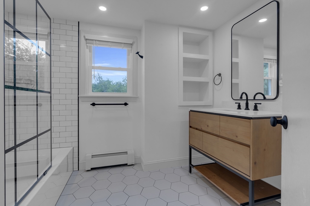 104 Mishawum Road Woburn, MA 01801 - Photo 9 of 13 a bathroom with a sink a mirror and shower