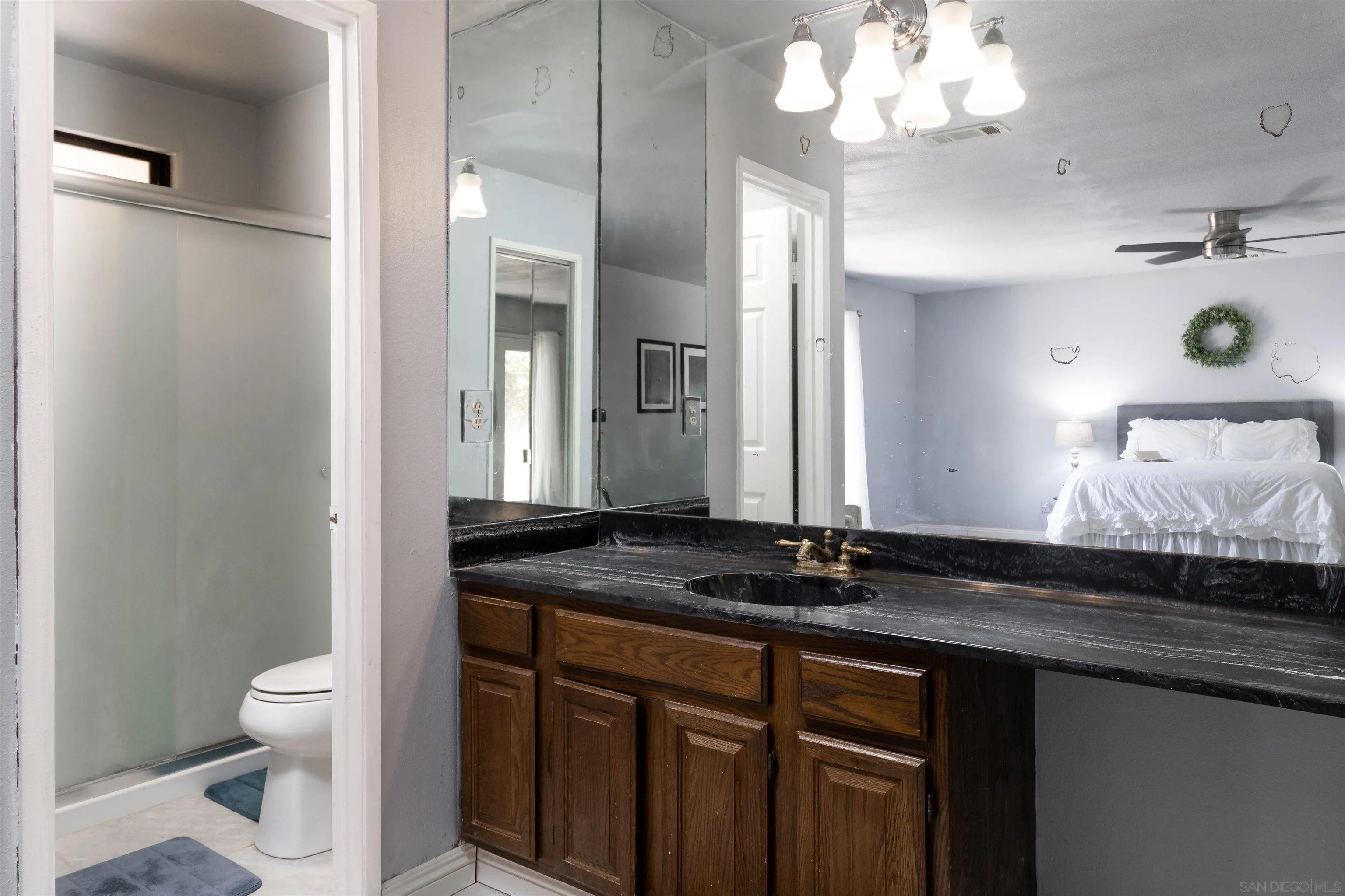 14011 Proctor Valley Road Jamul, CA 91935 - Photo 18 of 36 a bathroom with a granite countertop sink a toilet and a mirror