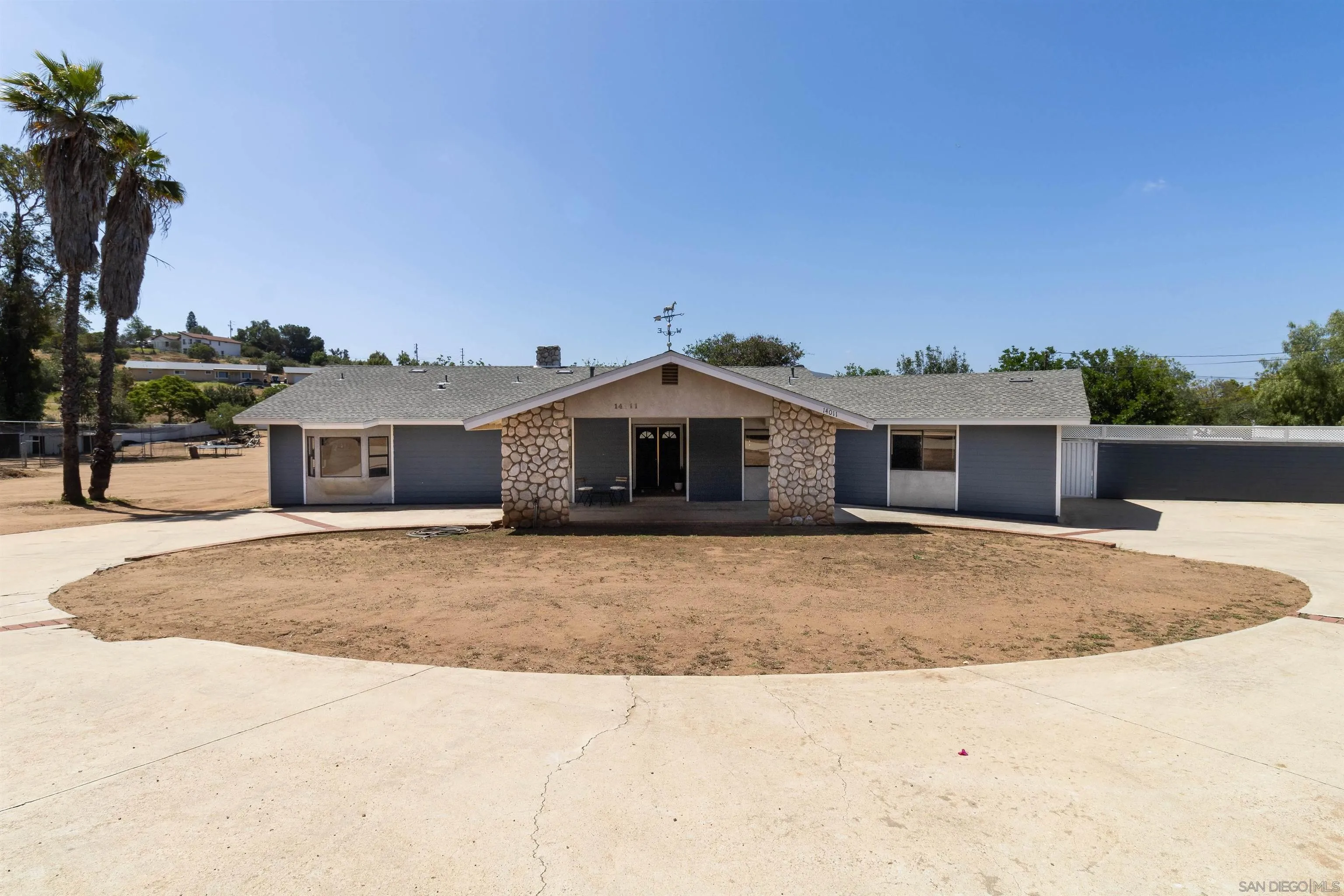 14011 Proctor Valley Road Jamul, CA 91935 - Photo 3 of 36 a large house with a big yard and large trees