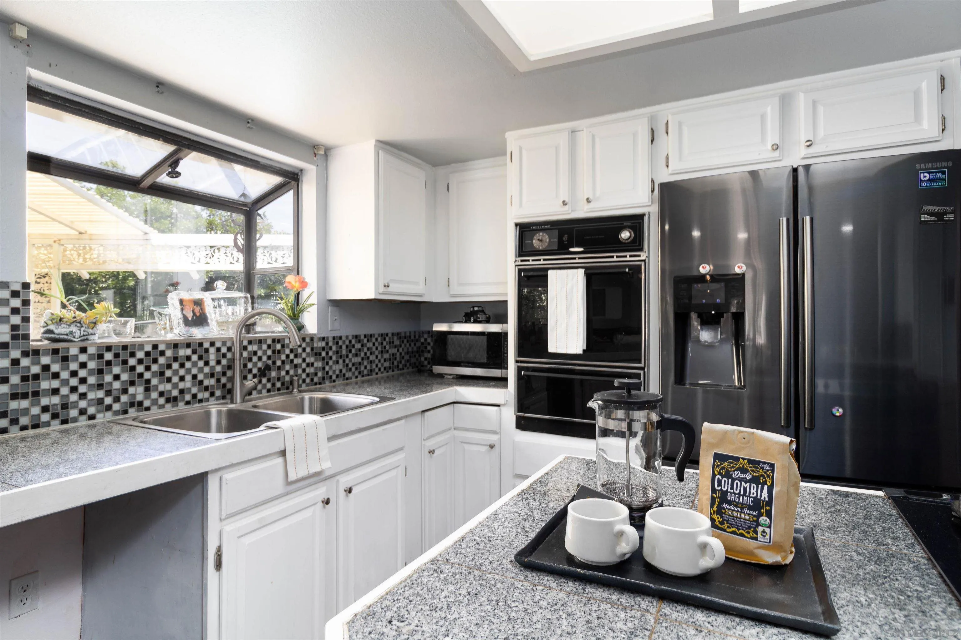 14011 Proctor Valley Road Jamul, CA 91935 - Photo 7 of 36 a kitchen with a sink a stove and white cabinets
