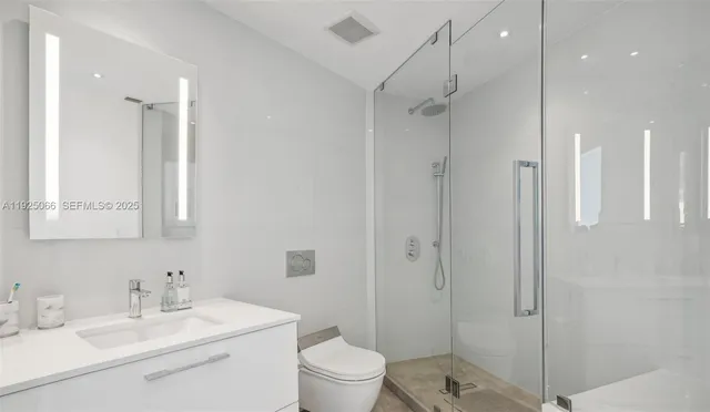 a bathroom with a sink toilet vanity and shower