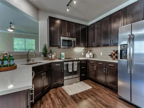 a kitchen with granite countertop stainless steel appliances and wooden cabinets