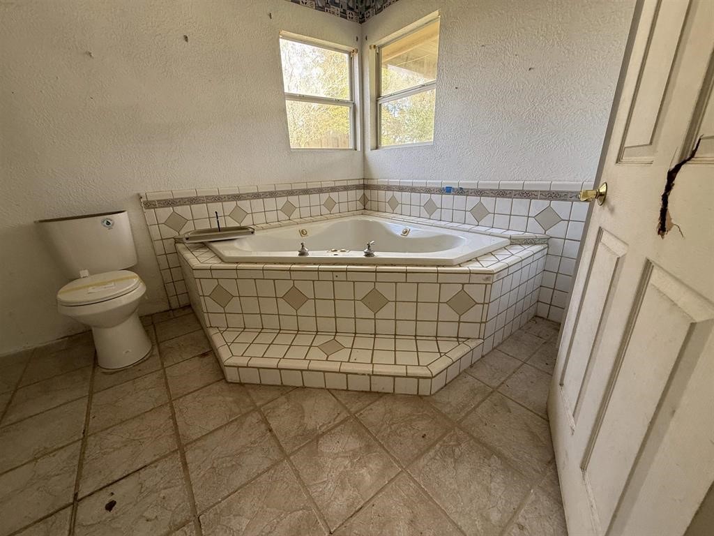 9283 Largent Road Hull, TX 77564 - Photo 16 of 22 a bathroom with a sink a toilet and a window
