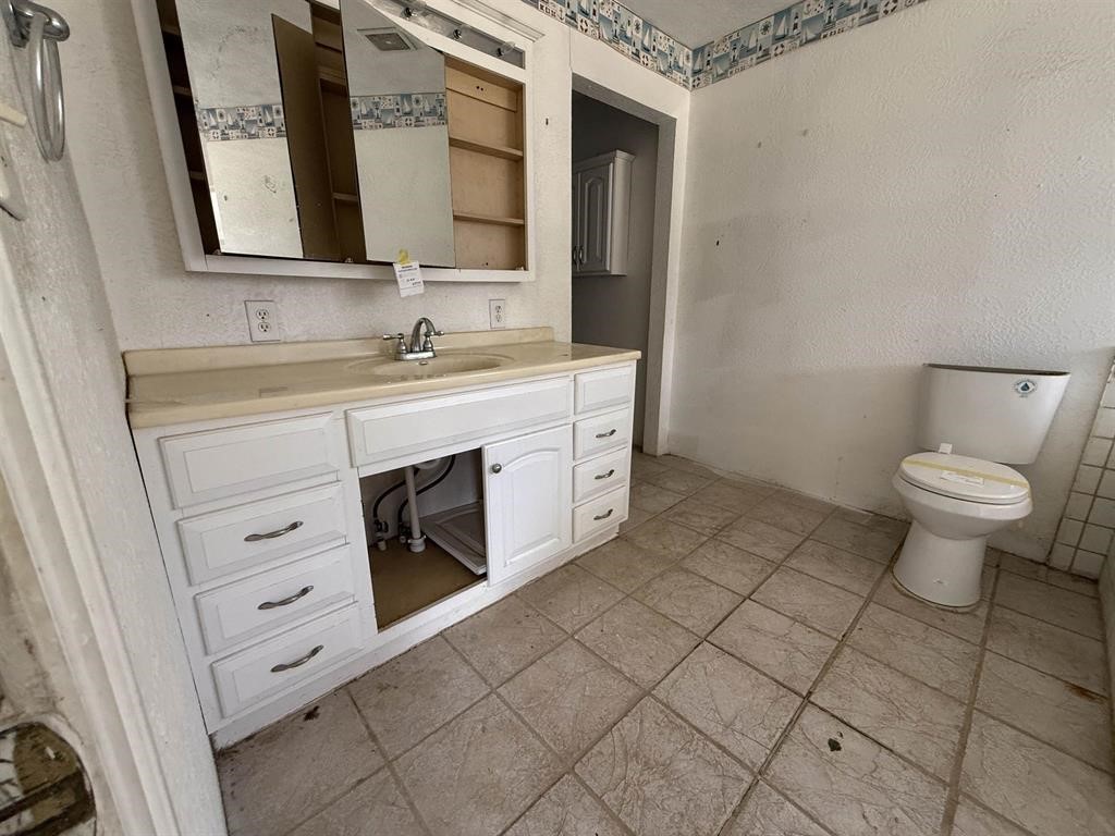 9283 Largent Road Hull, TX 77564 - Photo 17 of 22 a spacious bathroom with a toilet sink and a mirror