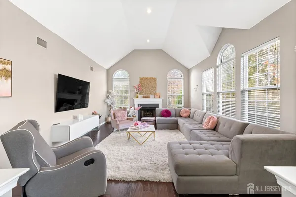 a living room with furniture a large window and a flat screen tv