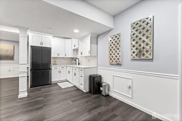 a kitchen with granite countertop a refrigerator a sink a stove a refrigerator and white cabinets