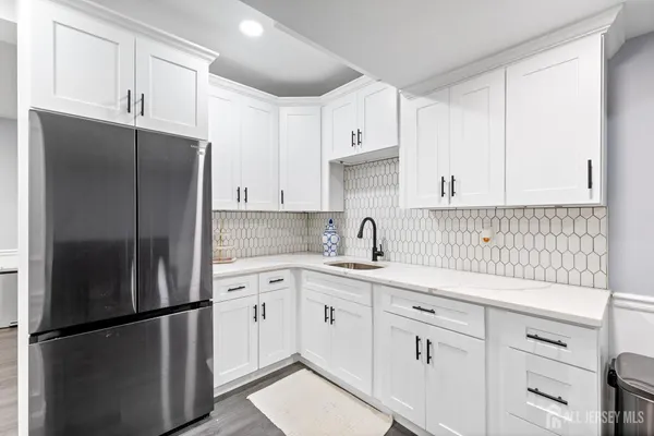 a kitchen with stainless steel appliances white cabinets and a refrigerator