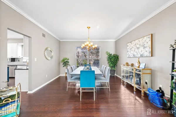 a dining room with furniture a chandelier and wooden floor