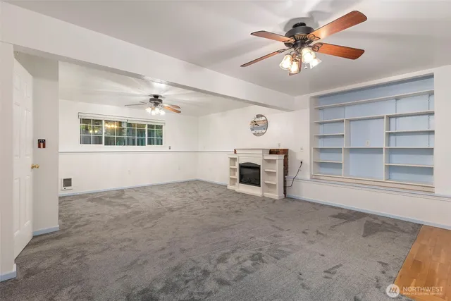 a view of empty room with a fireplace and fan