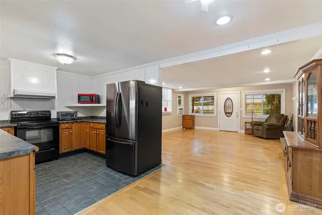 a kitchen with stainless steel appliances wooden floor and large window