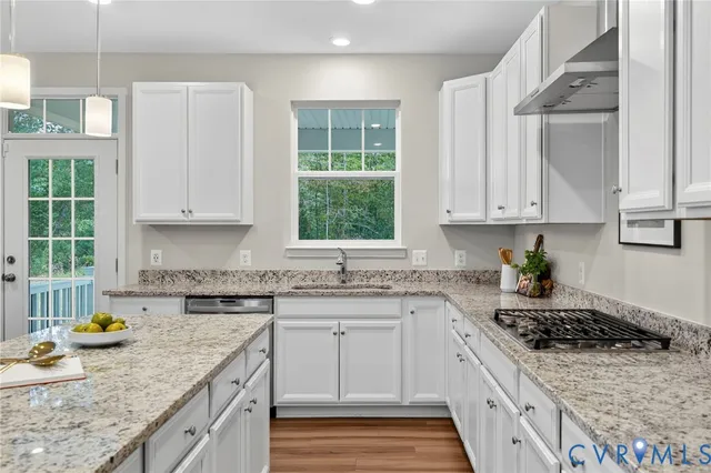 a kitchen with stainless steel appliances granite countertop a sink stove and cabinets