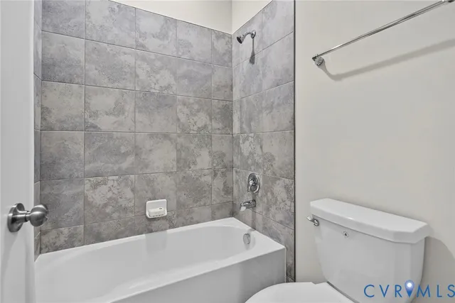 a white bath tub sitting next to a toilet