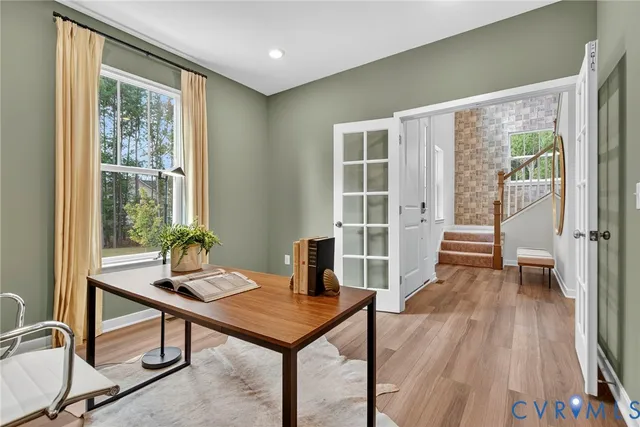 a view of a workspace with furniture and a window