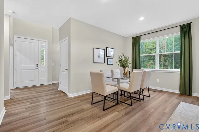 a dining room with wooden floor and a floor to ceiling window