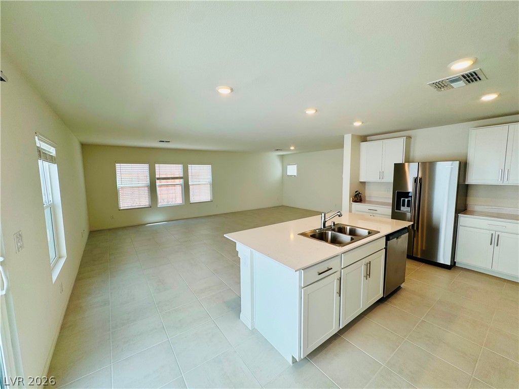 9249 Innot Avenue Las Vegas, NV 89148 - Photo 3 of 24 A well-lit kitchen with sleek appliances seamlessly flows into a spacious living area.