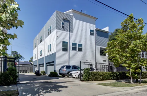 a view of a white building among the street with palm trees