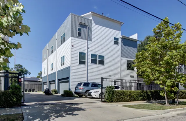 a view of a white building among the street with palm trees