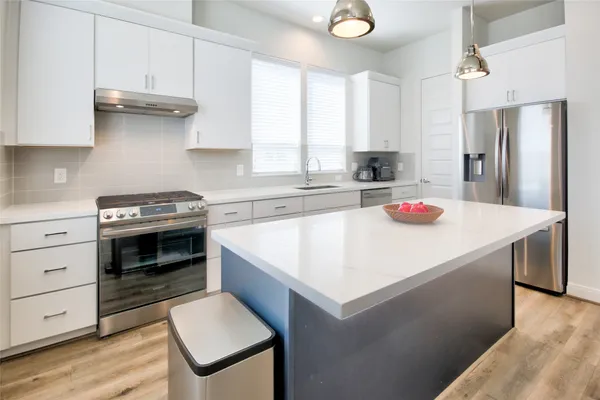 a kitchen with granite countertop a sink stove and refrigerator