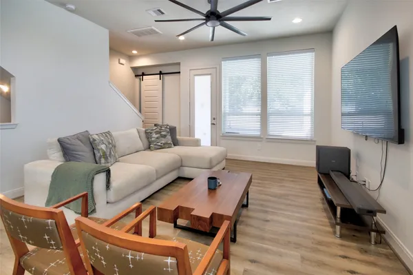 a living room with furniture and wooden floor