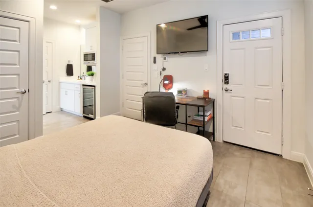 a large white bed in a room next to a window