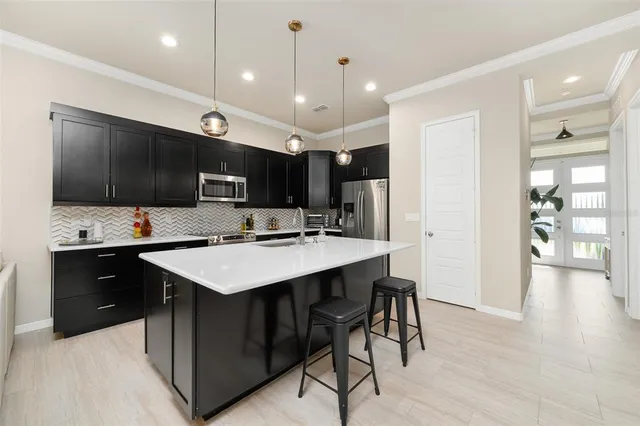 a kitchen with a sink a counter top space appliances and cabinets