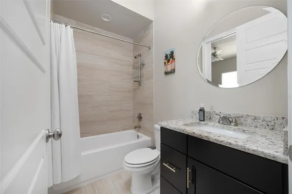 a bathroom with a granite countertop sink mirror and bathtub