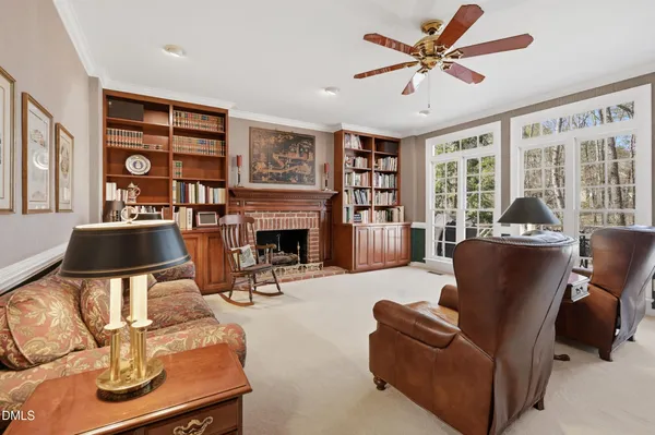 a living room with furniture a fireplace and a large window