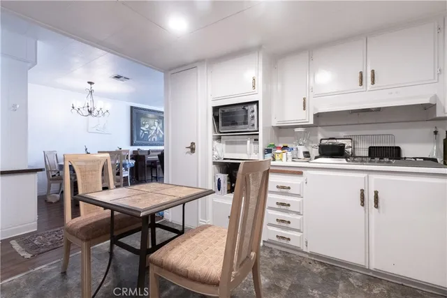 a kitchen with a dining table chairs appliances and cabinets
