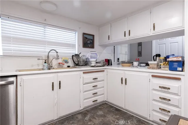 a kitchen with cabinets appliances a sink and a window