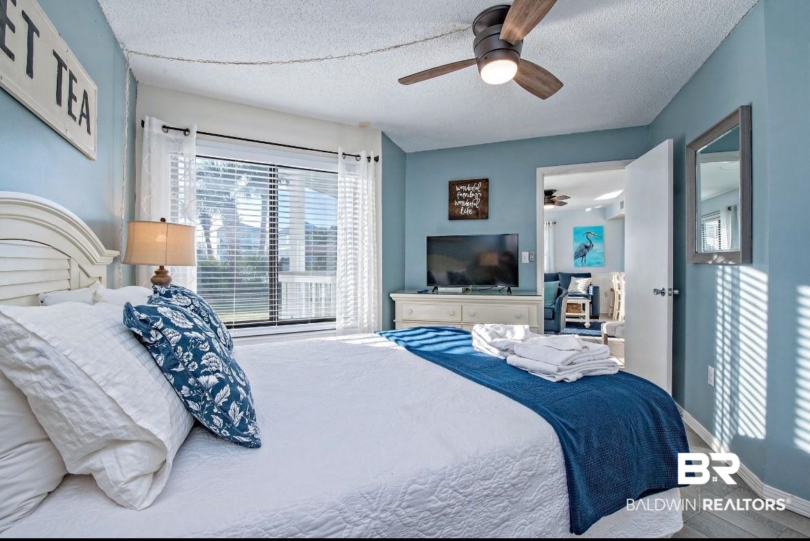 497 Plantation Road, Unit 1156 Gulf Shores, AL 36542 - Photo 13 of 28 Bedroom with a textured ceiling, baseboards, ceiling fan, and wood finished floors