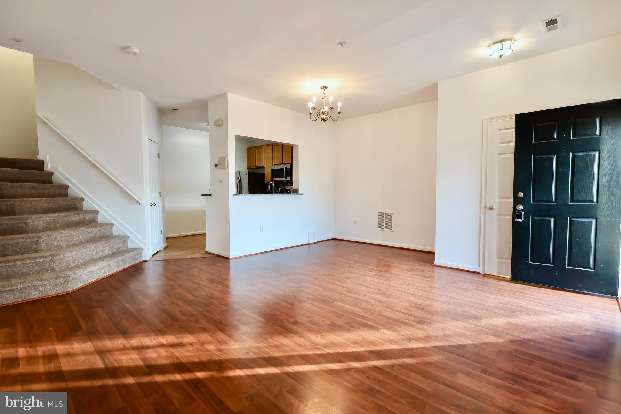 303 Three Sirens Odenton, MD 21113 - Photo 6 of 24 a view of a livingroom with wooden floor and a kitchen