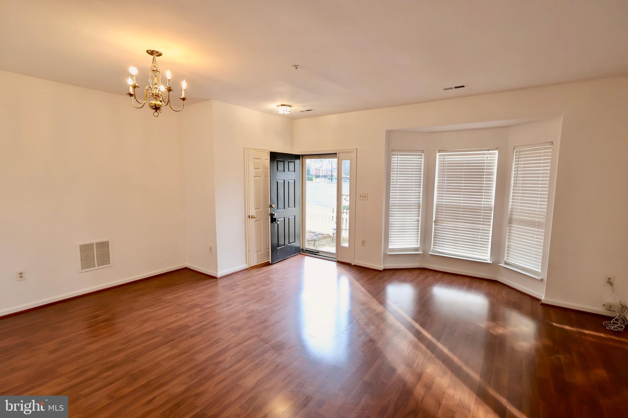 303 Three Sirens Odenton, MD 21113 - Photo 7 of 24 a view of an empty room with glass door and wooden floor