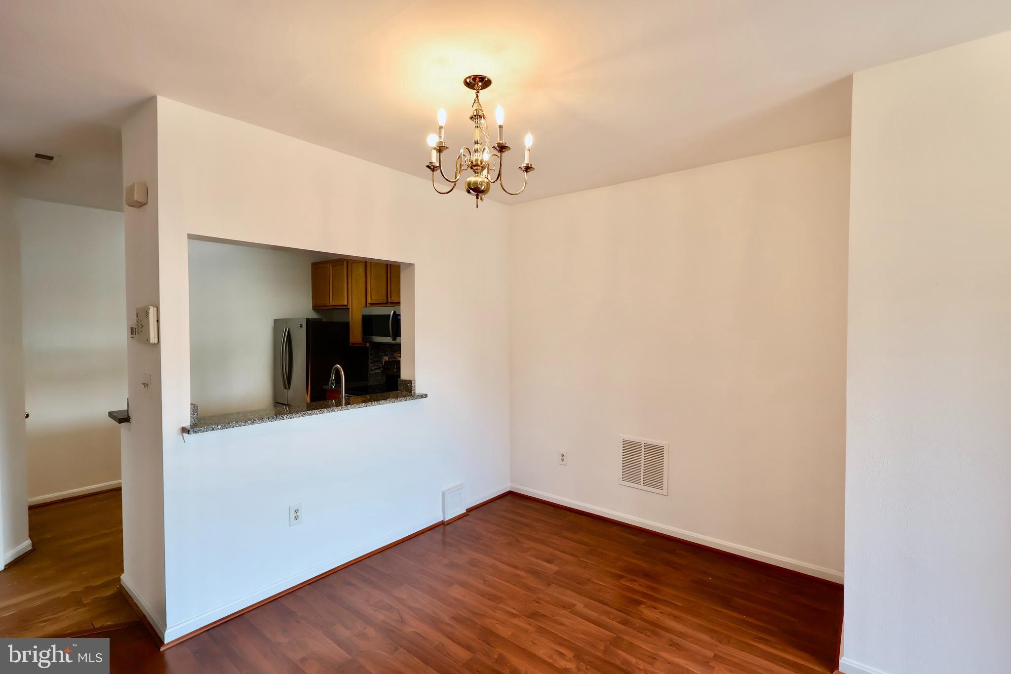 303 Three Sirens Odenton, MD 21113 - Photo 8 of 24 a view of a hallway with wooden floor and a chandelier