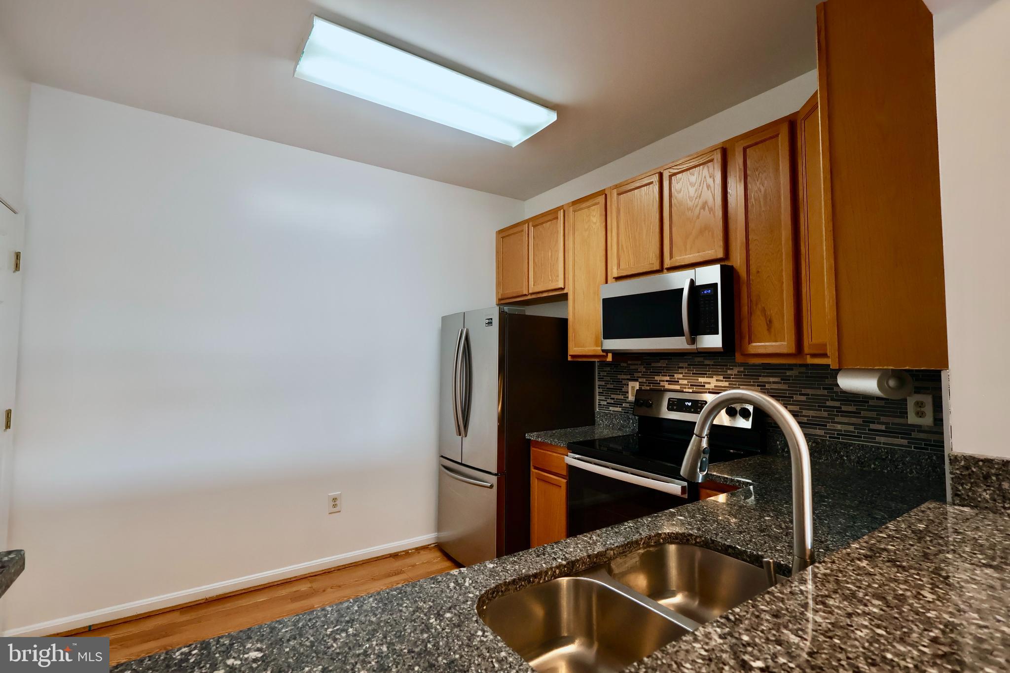 303 Three Sirens Odenton, MD 21113 - Photo 9 of 24 a kitchen with a sink and a refrigerator