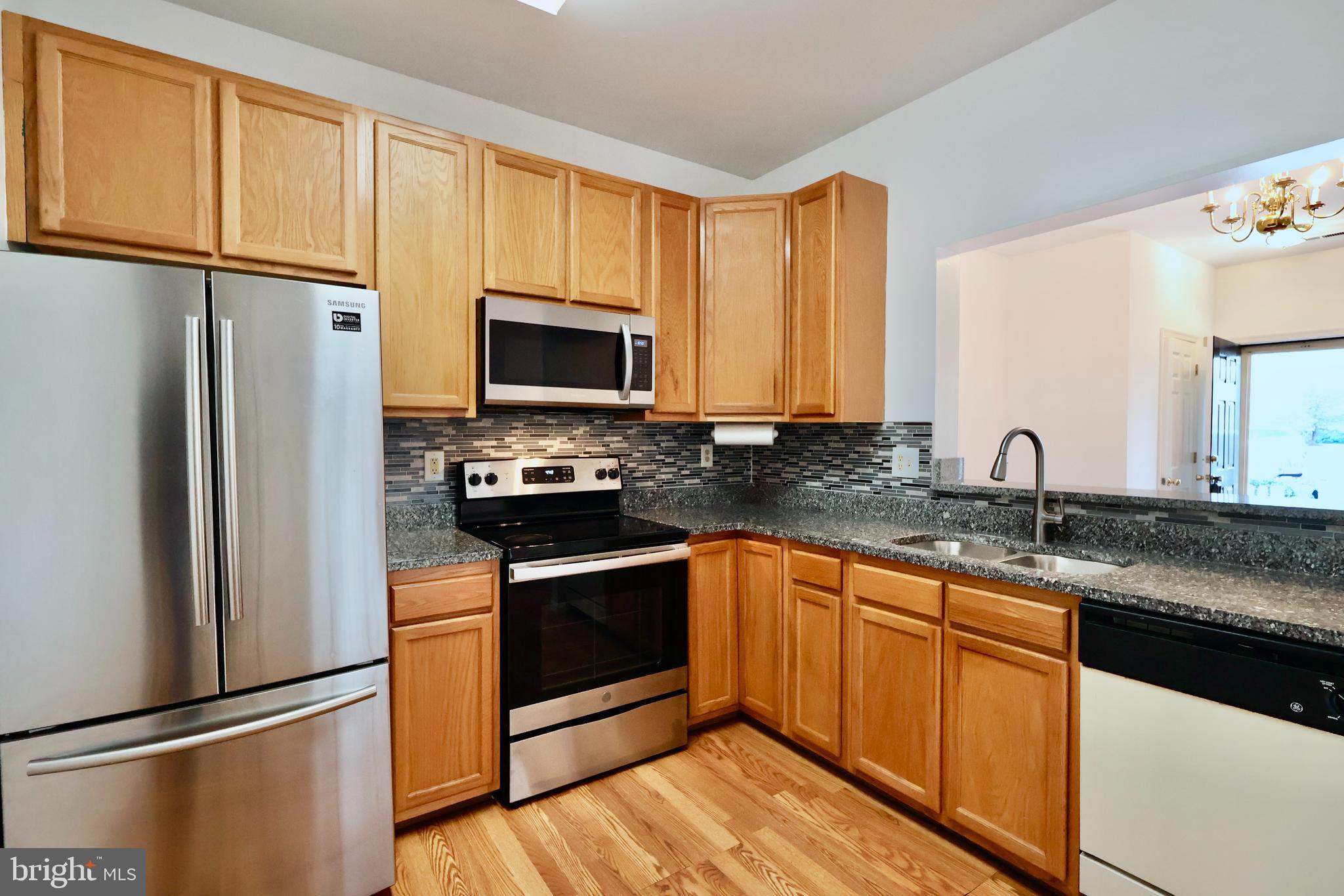 303 Three Sirens Odenton, MD 21113 - Photo 10 of 24 a kitchen with stainless steel appliances granite countertop a refrigerator stove microwave and sink