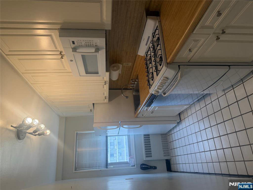 280 Prospect Avenue, Unit 5D Hackensack, NJ 07601 - Photo 13 of 21 a kitchen with a stove a sink and cabinets