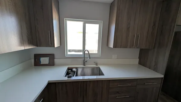 a kitchen with a sink a window and cabinets