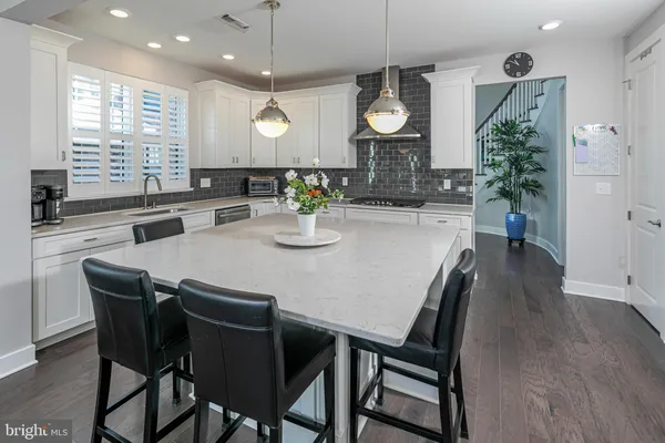 a kitchen with a dining table chairs and living room view