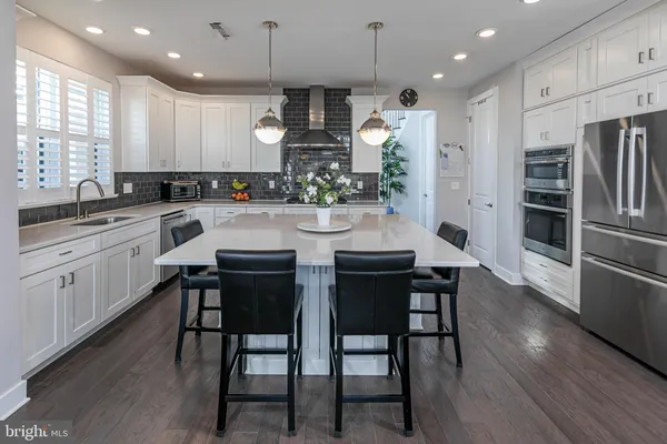 a kitchen with refrigerator a sink and chairs