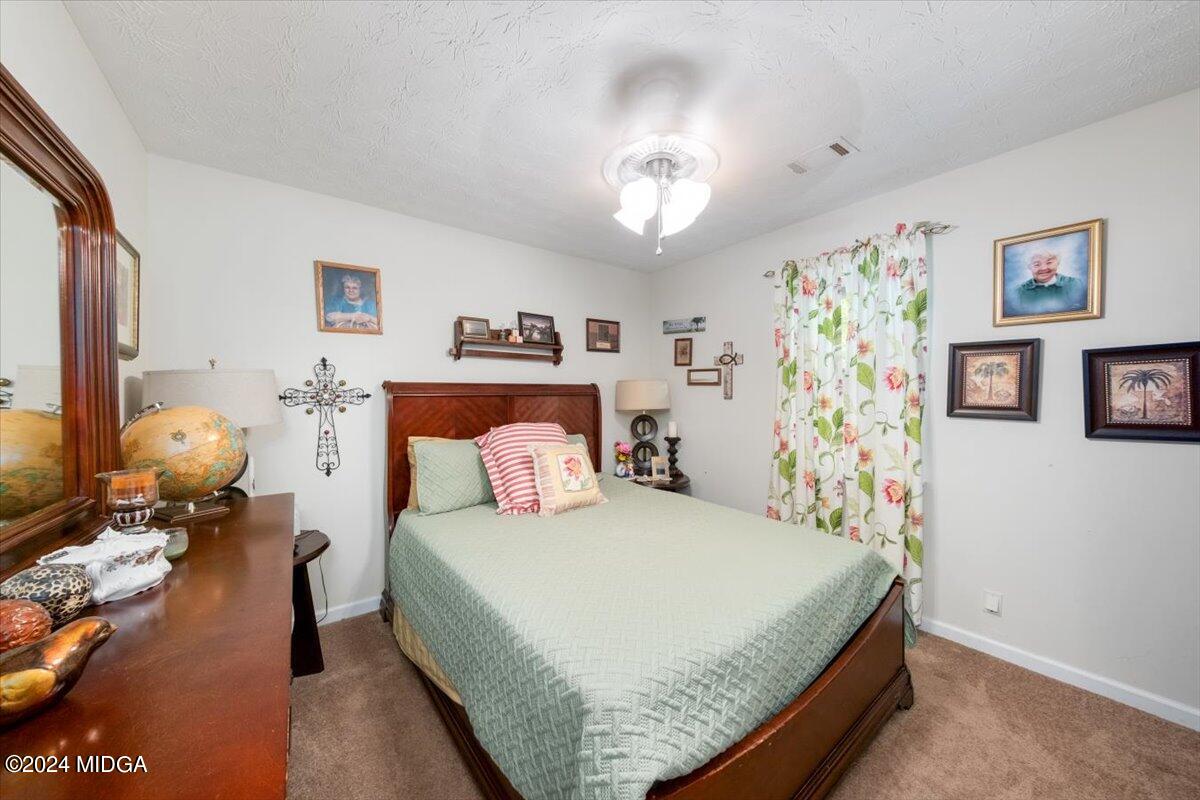 1426 Teagle Road Forsyth, GA 31029 - Photo 15 of 27 a bedroom with a bed and furniture