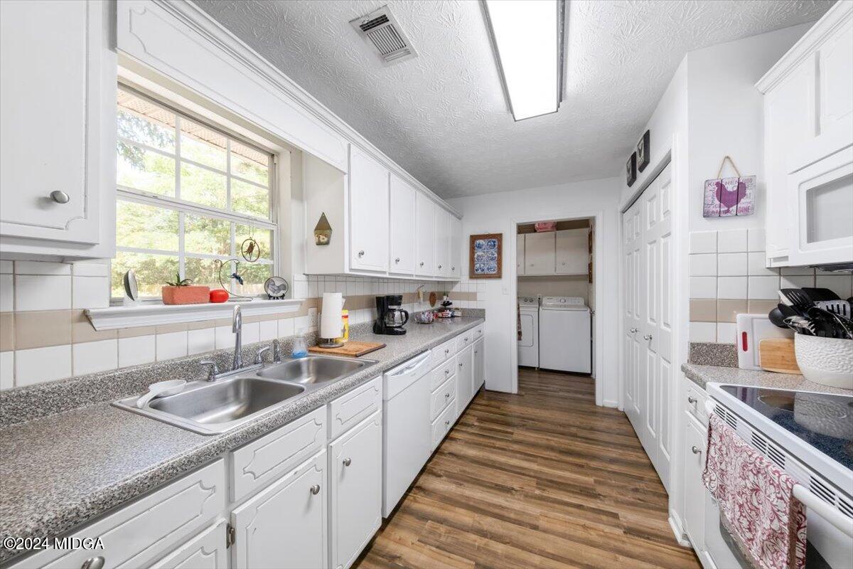 1426 Teagle Road Forsyth, GA 31029 - Photo 9 of 27 a kitchen with a sink stove cabinets and wooden floor