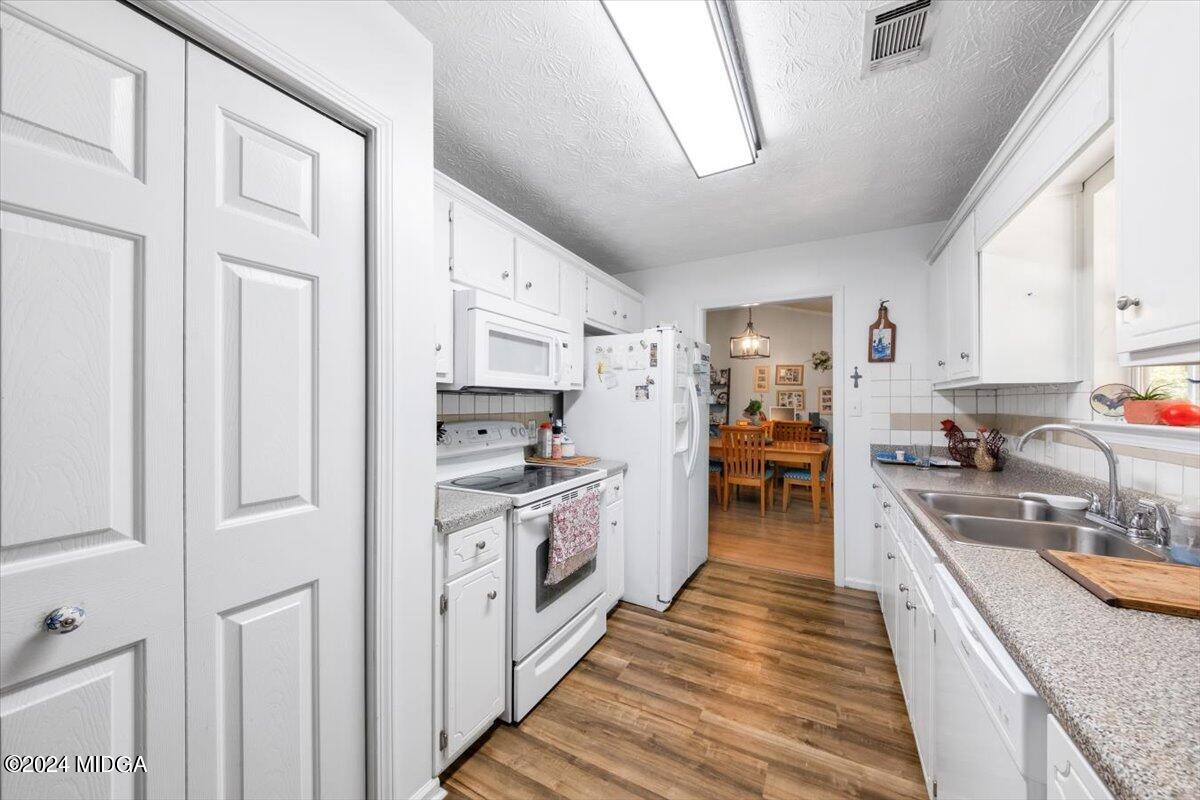 1426 Teagle Road Forsyth, GA 31029 - Photo 10 of 27 a large kitchen with stainless steel appliances granite countertop a lot of counter space and wooden floors