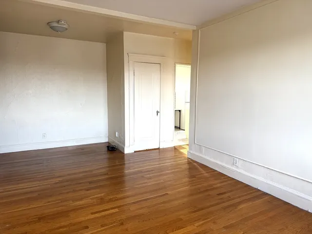 a view of an empty room and wooden floor