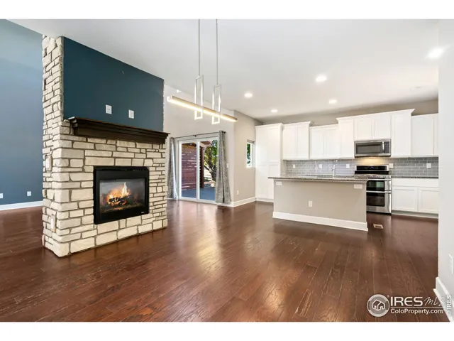 a view of kitchen with kitchen island wooden floor and electronic appliances
