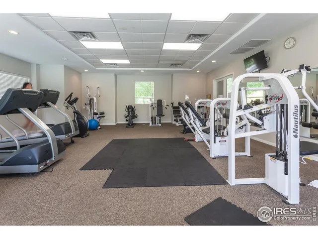 a living room with lots of furniture and gym equipment
