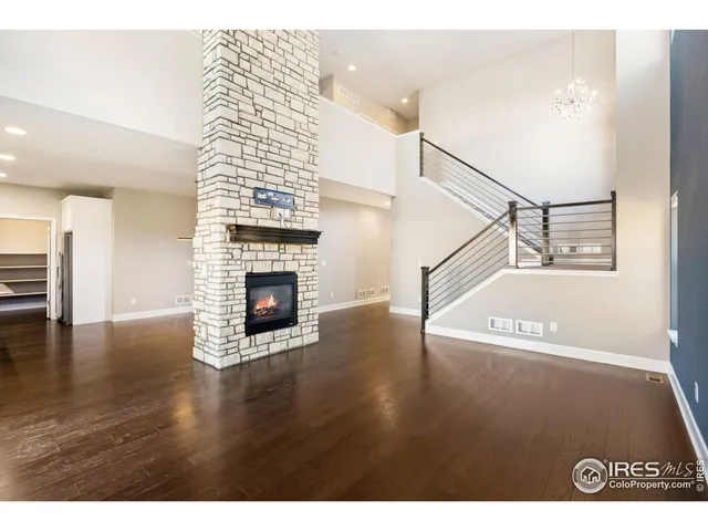 a view of a livingroom with wooden floor fireplace and stairs