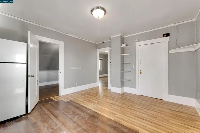 a view of empty room with wooden floor